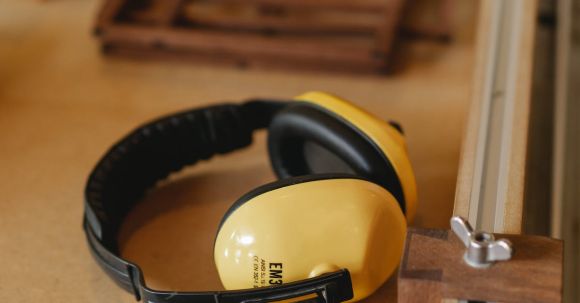Noise-Canceling Headphones - Protective headphones for woodwork on wooden table